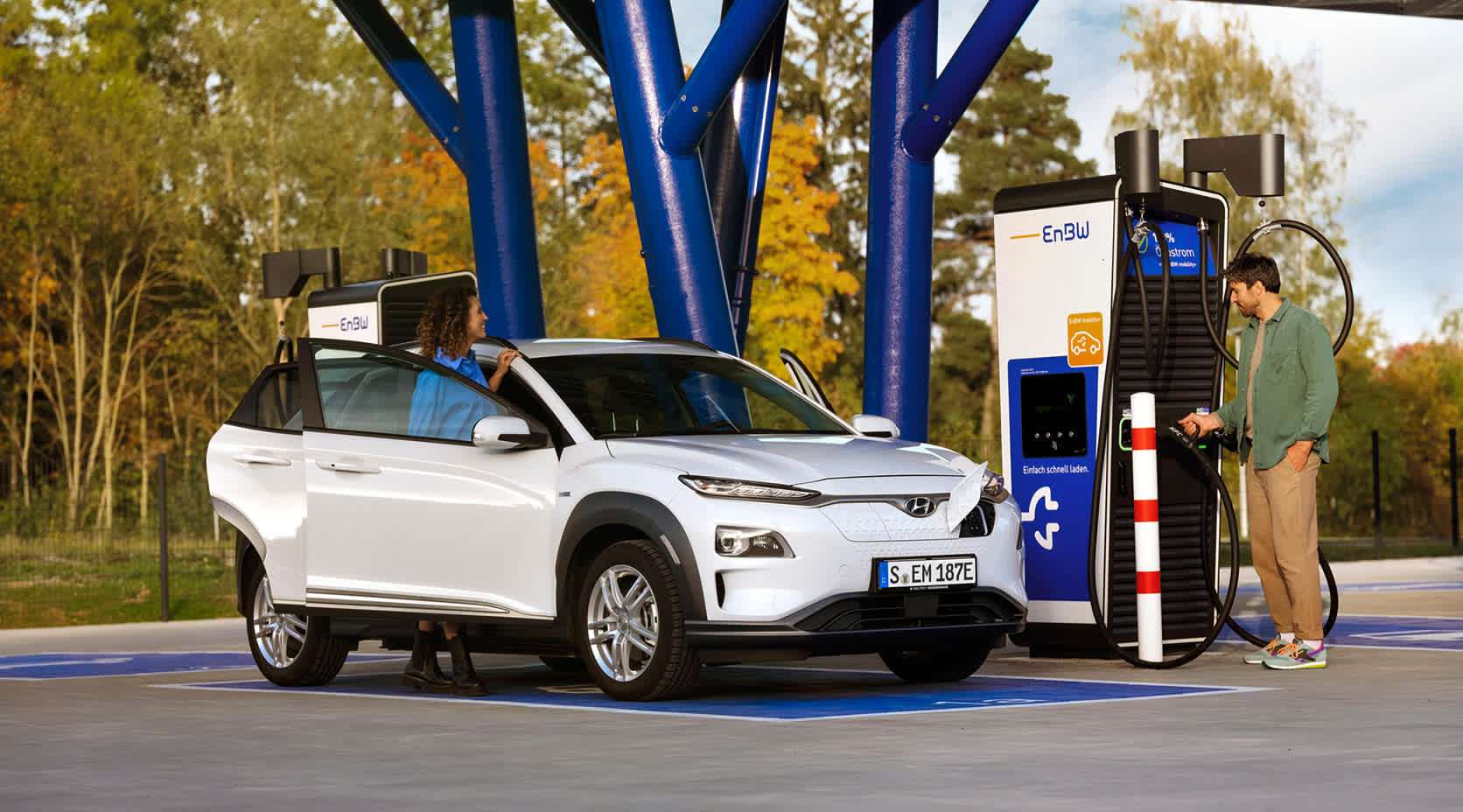 Paar lädt Auto an EnBw Ladestation