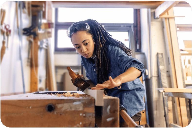 Junge Frau, die ihre Ausbildung in einer Schreinerei macht