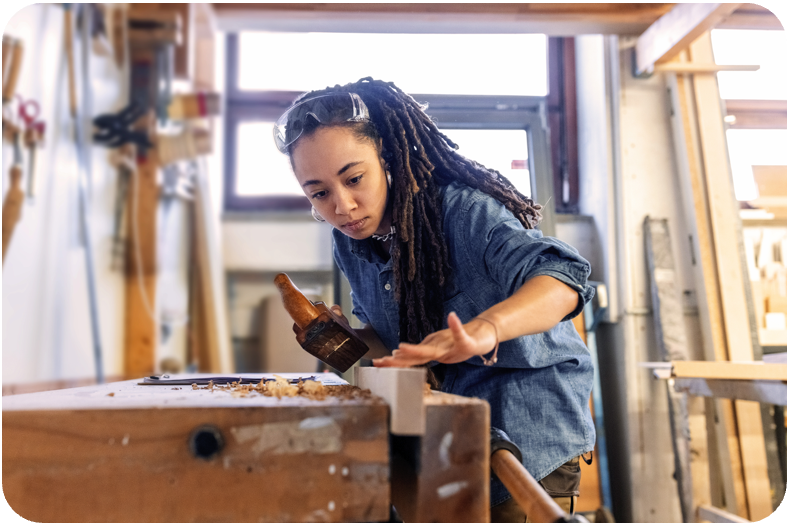 Junge Frau, die ihre Ausbildung in einer Schreinerei macht