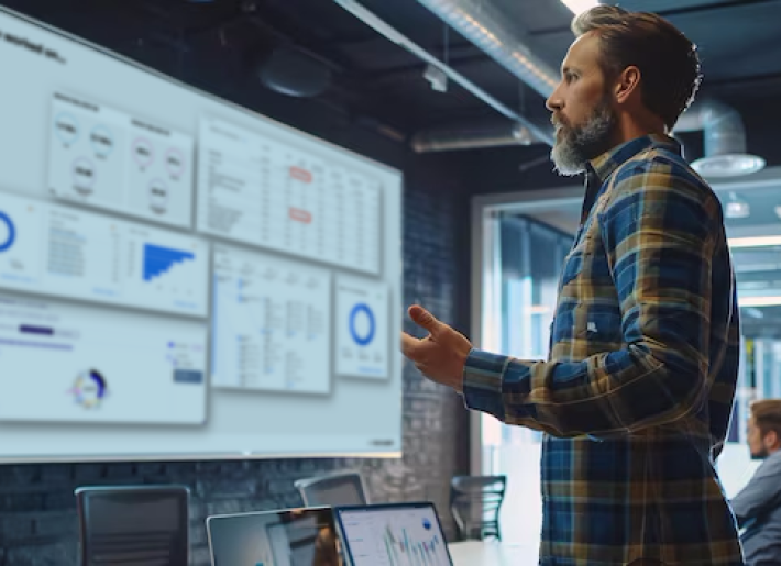 Ein Mann blickt auf Datenauswertungen auf mehreren Bildschirmen.