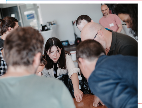 Mehrere Personen von port-neo arbeiten gemeinsam an einem Tisch und entwickeln im Team Lösungen.