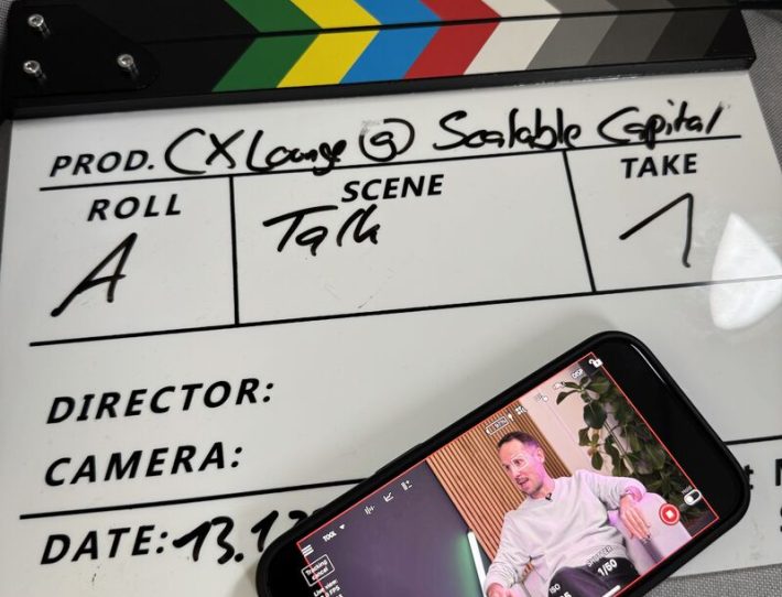 Filmklappt mit Smartphone. Auf dem Display ist Maximilian Meyer zu sehen.
